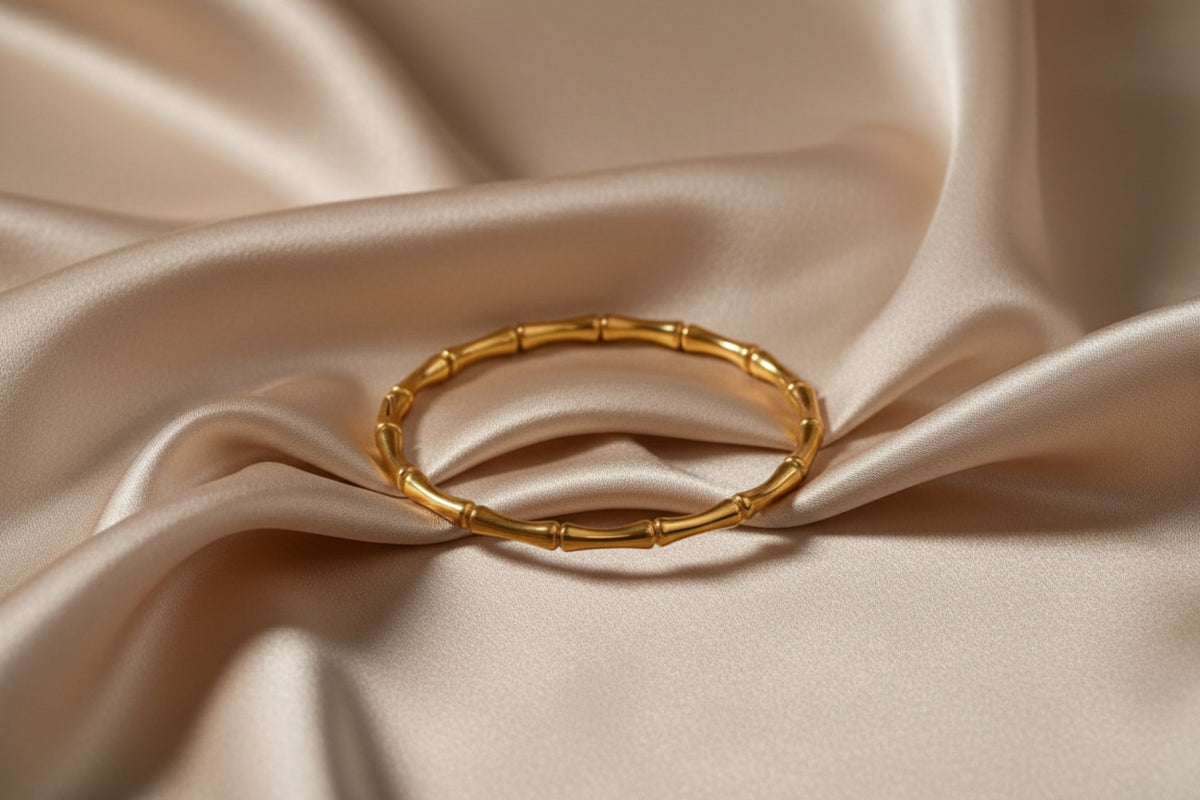 Altin Noor gold-tone metal bangle bracelet with a segmented bamboo-inspired design and a polished finish.