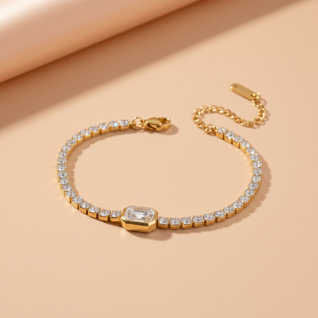 Altin Noor gold-tone tennis bracelet featuring shimmering clear crystals and a central rectangular-cut stone.