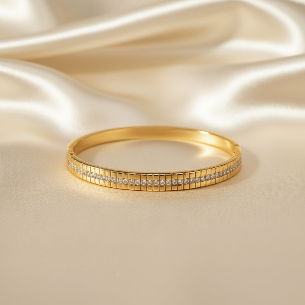 Altin Noor gold-tone hinged bangle bracelet featuring a central row of sparkling cubic zirconia stones.