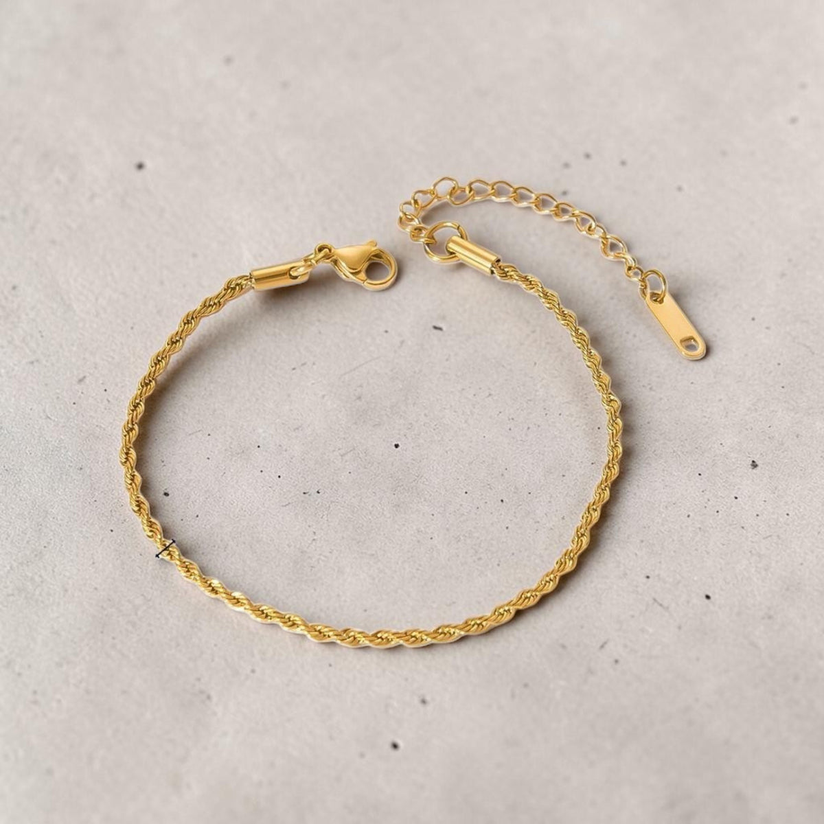 Altin Noor gold-tone twisted rope chain bracelet with a lobster clasp and adjustable extension on a grey background