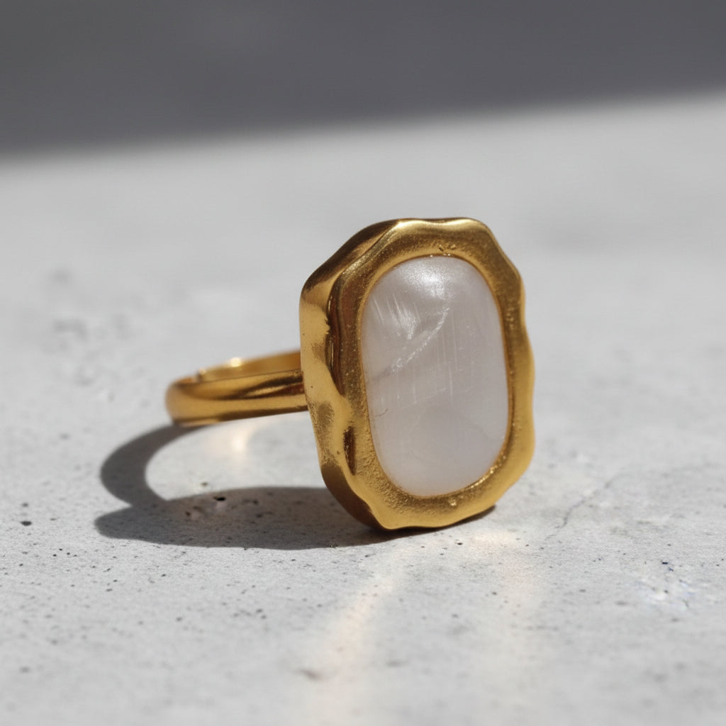 Altin Noor gold-tone statement ring featuring an organic molten frame and a smooth pearlescent white stone centrepiece.