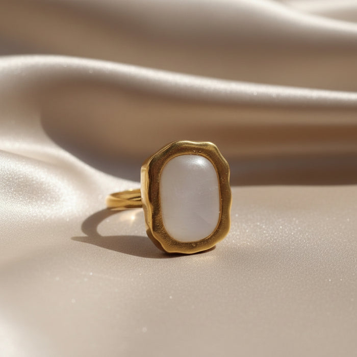 Altin Noor gold-tone statement ring featuring an organic molten frame and a smooth pearlescent white stone centrepiece.