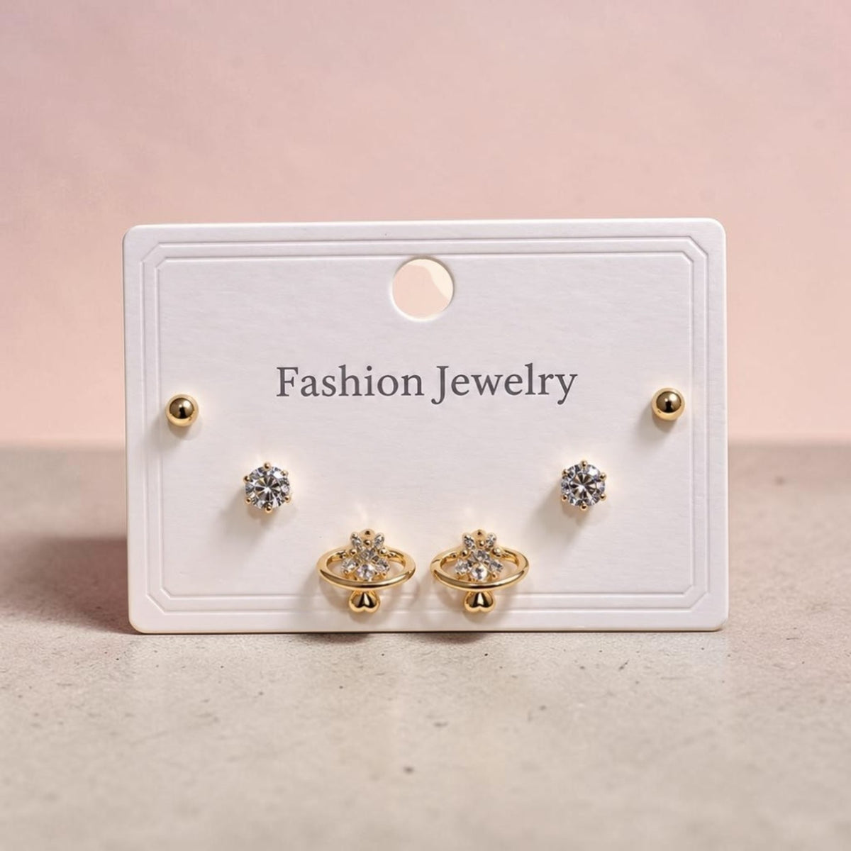 Altin Noor three-piece gold-tone earring set featuring minimalist spheres, solitaire studs, and crystal planet hoops.