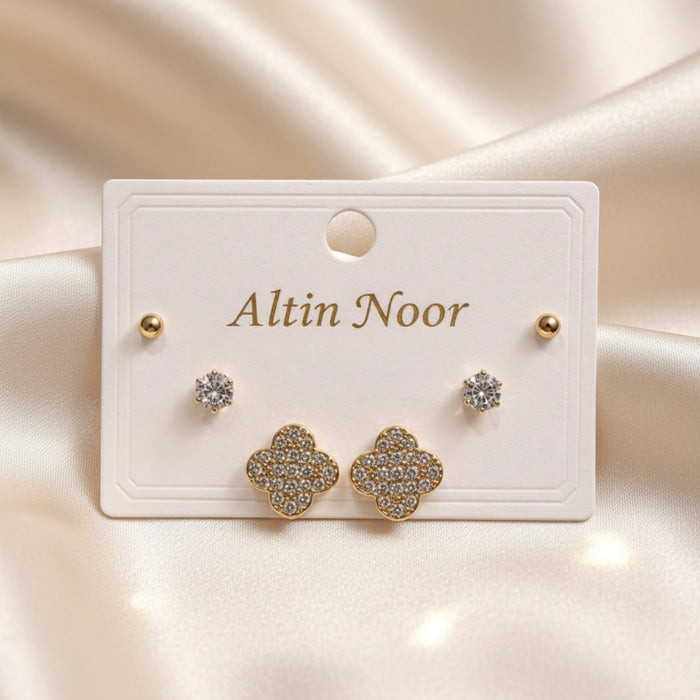 Altin Noor three-piece gold-tone earring set featuring ball studs, solitaire crystals, and pavé clover motifs.